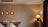 Evening dining room lit by three smoked glass globe pendants and a table lamp